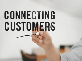 Hand writing connecting customers concept on clear screen with blurred office background.