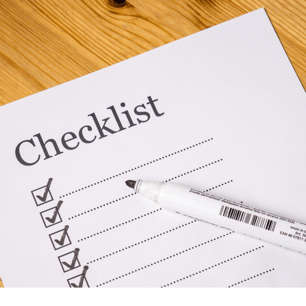 Checklist paper with checkboxes and a black pen placed on a wooden surface, representing planning and productivity tasks.
